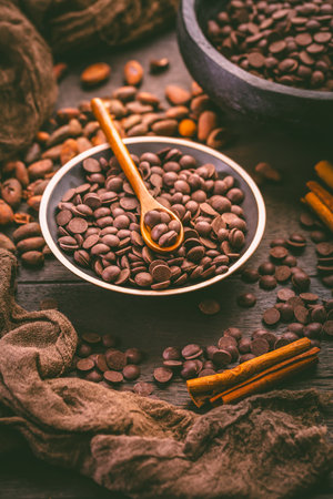 Bittersweet dark chocolate drops with cocoa beans, sugar-free couverture, baking and cooking ingredientの写真素材