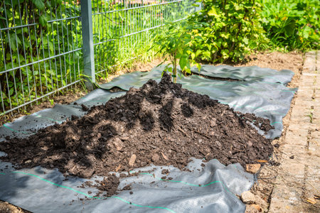 Installing weed control fabric material and bark mulch in a residential garden to control weed...