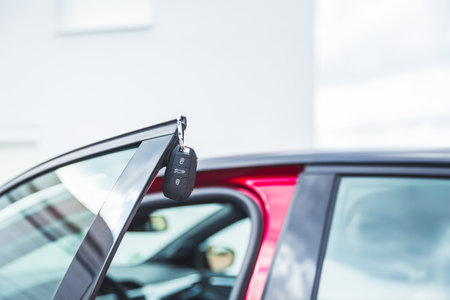 Car keys on open door - concept of buying or leasing new carの写真素材