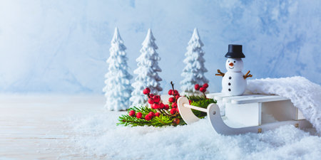 Winter decoration, snowman on sleigh in snowy landscapeの写真素材
