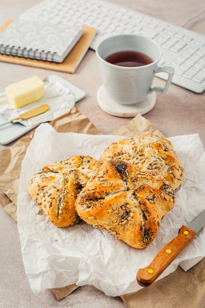 Lunch in an office, delicious bread rolls with butter and coffee on desktopの写真素材