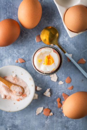 Breakfast with boiled eggs, cup of tea, milk and oat cookies