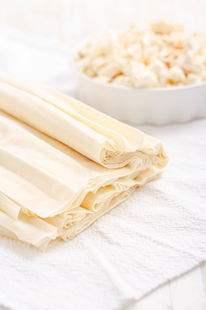 Raw phyllo dough with feta cheese, prepared for filling, making savory pastry, Filo dough