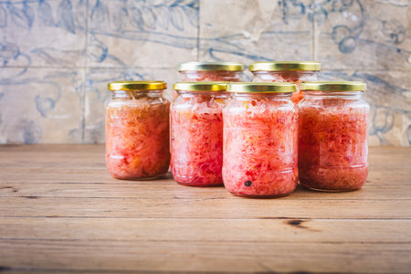 Cabbage sauerkraut with beetroot in jars. Fermented preserved vegetarian food concept.の写真素材