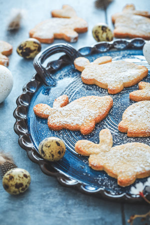 Homemade almond bunny cookies for Easter with Easter eggs in blue tone
