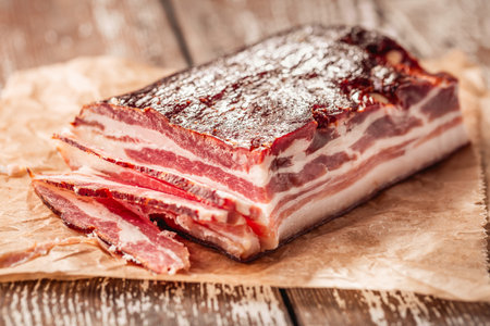Bacon on wooden kitchen table, dry cured porkの写真素材