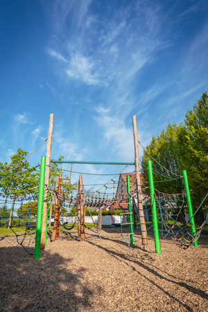 Empty public playground on sunny day with play equipment made from wood