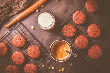 Cup of hot coffee and chocolate cookies for breakfast or snack on wooden tableの写真素材