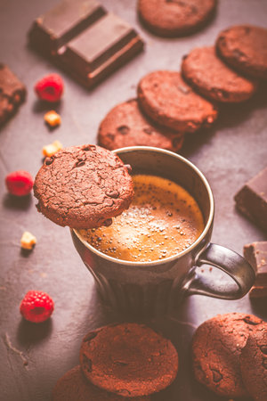 Cup of hot coffee and chocolate cookies for breakfast  or snack on wooden tableの写真素材