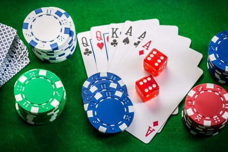 Playing cards, dice and poker chips on green background
