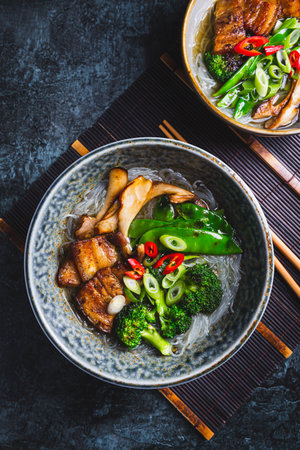 Ramen soup with mushrooms, vegetables, glass noodles and porkの写真素材