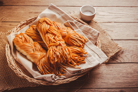 Smoked braided cheese, salty chechil cheese on wooden cutting boardの写真素材