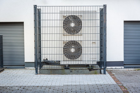 Two air source heat pumps installed outside of new and modern city house, green renewable energy concept of heat pumpの写真素材