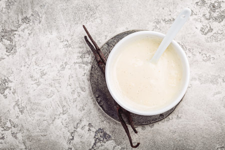Homemade vanilla sauce in small bowl on gray backgroundの写真素材