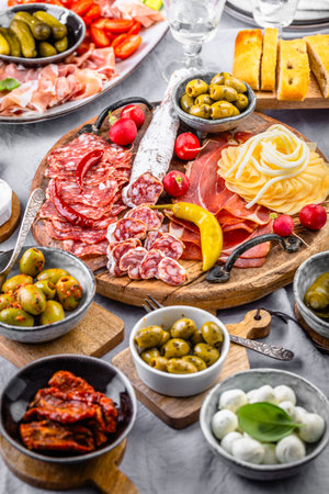 Assorted appetizers and antipasti platters on wooden tray, catering concept with meats and cheeseの写真素材