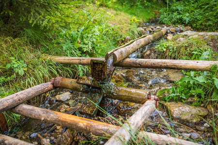 Small wooden water mill built for kids on small creek, playing outdoors concept