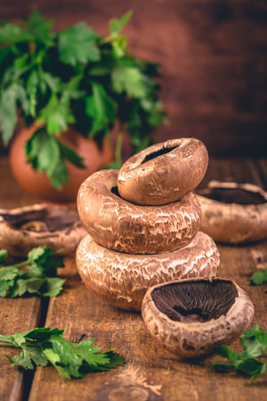 Mushrooms Porto Bello on kitchen table with fresh herbsの写真素材