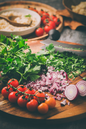 Ingredients for homemade Tabouleh couscous salad with fresh vegetables and herbs on cutting boardの写真素材