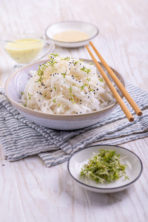 Freshly grated kohlrabi salad with herbs and creamy dressing on a wooden table