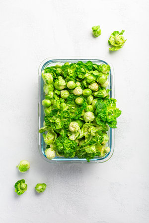 Fresh  organic green brussels sprouts and small winter cabbage vegetable in glass container, ready to freezeの写真素材