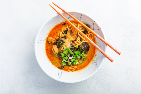Thai red curry noodle soup with shiitake,  coconut milk and  green onionsの写真素材