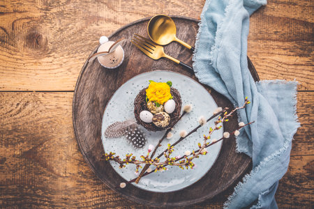 Easter table setting with spring flowers and cutlery on wooden table.  Spring Easter Holiday Tableの写真素材