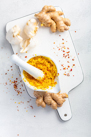 Homemade Fresh Ginger and Garlic paste or Adrak Lahsun puree in ceramic bowl on white background.  Asian cuisineの写真素材