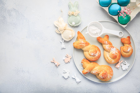 Easter baking - Buns made from yeast dough in a shape of Easter bunny and colored eggsの写真素材