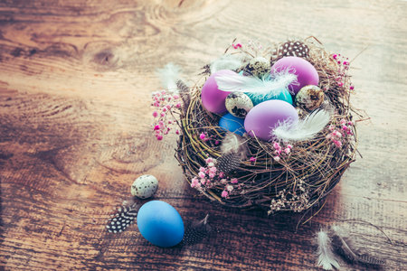 Happy Easter - nest with Easter eggs on wooden background with copy spaceの写真素材