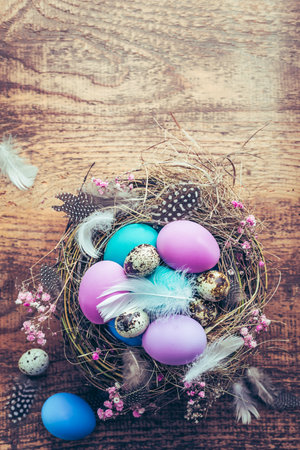 Happy Easter - nest with Easter eggs on wooden background with copy spaceの写真素材