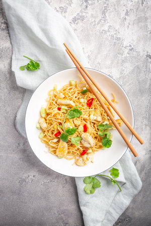 Stir fried noodles with chicken and vegetable in white bowl. Asian style food.の写真素材