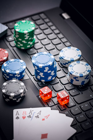 Online poker. Chips, cards and dice nearby keyboard. Betting services on Internet. Gambling on website and winning money. Play poker online at home.の写真素材