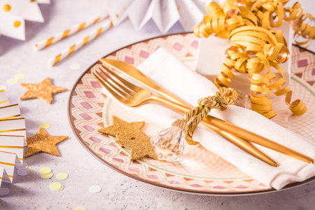 Festive place setting for Christmas and New Year with paper  fans in golden toneの写真素材