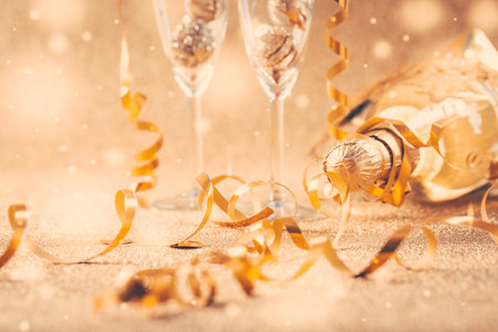 Happy New Years Eve and Christmas celebration with 2 glasses , champagne and ornaments in golden toneの写真素材