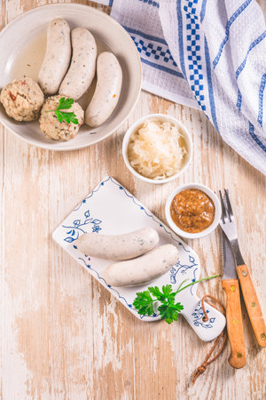 Traditional Bavarian cuisine - White veal sausage (Weisswurst) with pickled white cabbage (Sauerkraut) and bread dumplings with  Mustard Sauceの写真素材