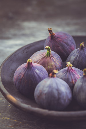 Fresh organic raw figs in a bowl  on wooden backgroundの写真素材