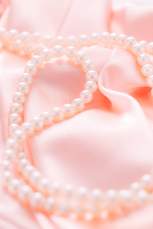 Pearl necklace on pink satin fabric. Wedding concept. Soft focusの写真素材