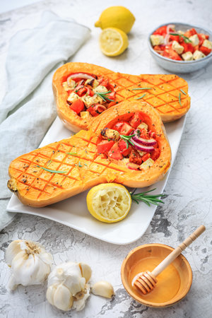Halved roasted butternut squash with spicy vegetable filling and feta cheeseの写真素材
