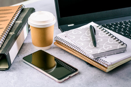 Modern office desk table with laptop, smartphone and other supplies with cup of coffeeの写真素材