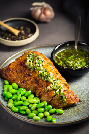 Grilled pork steak with edamame beans and Chimichurri sauceの写真素材