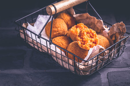 Homemade Arancini -  deep fried rice balls stuffed with Mozzarella cheese in basketの写真素材