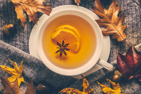 Hot lemon tea for cold  season with warm  sweater and autumn leavesの写真素材