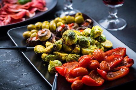 Assortment of appetizers and tapas with red wine on black backgroundの写真素材