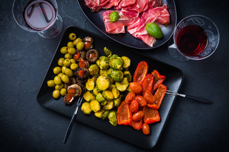 Assortment of appetizers and tapas with red wine on black backgroundの写真素材