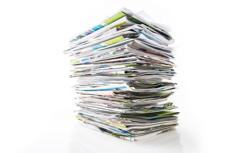 Stack of waste paper, old magazines, newspapers and leaflets for recycling isolated on whiteの写真素材