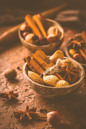 Assortment of different spices and nuts for Christmas baking in warm brown toneの写真素材