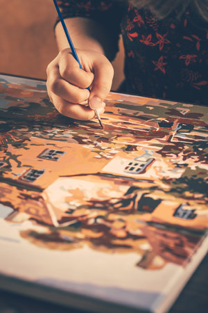 A hand with brush drawing picture of countryside with acrylic paints on canvas. Art concept.の写真素材
