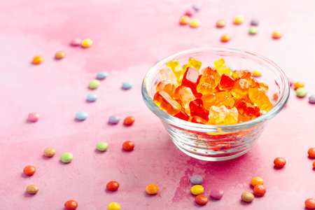 Gummy candy, colorful jelly bears in a bowl on pink background, selective focusの写真素材