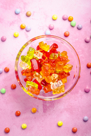 Gummy candy, colorful jelly bears in a bowl on pink background, selective focusの写真素材
