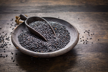 Beluga lentils on wooden background. Black lentils in bowl.の写真素材